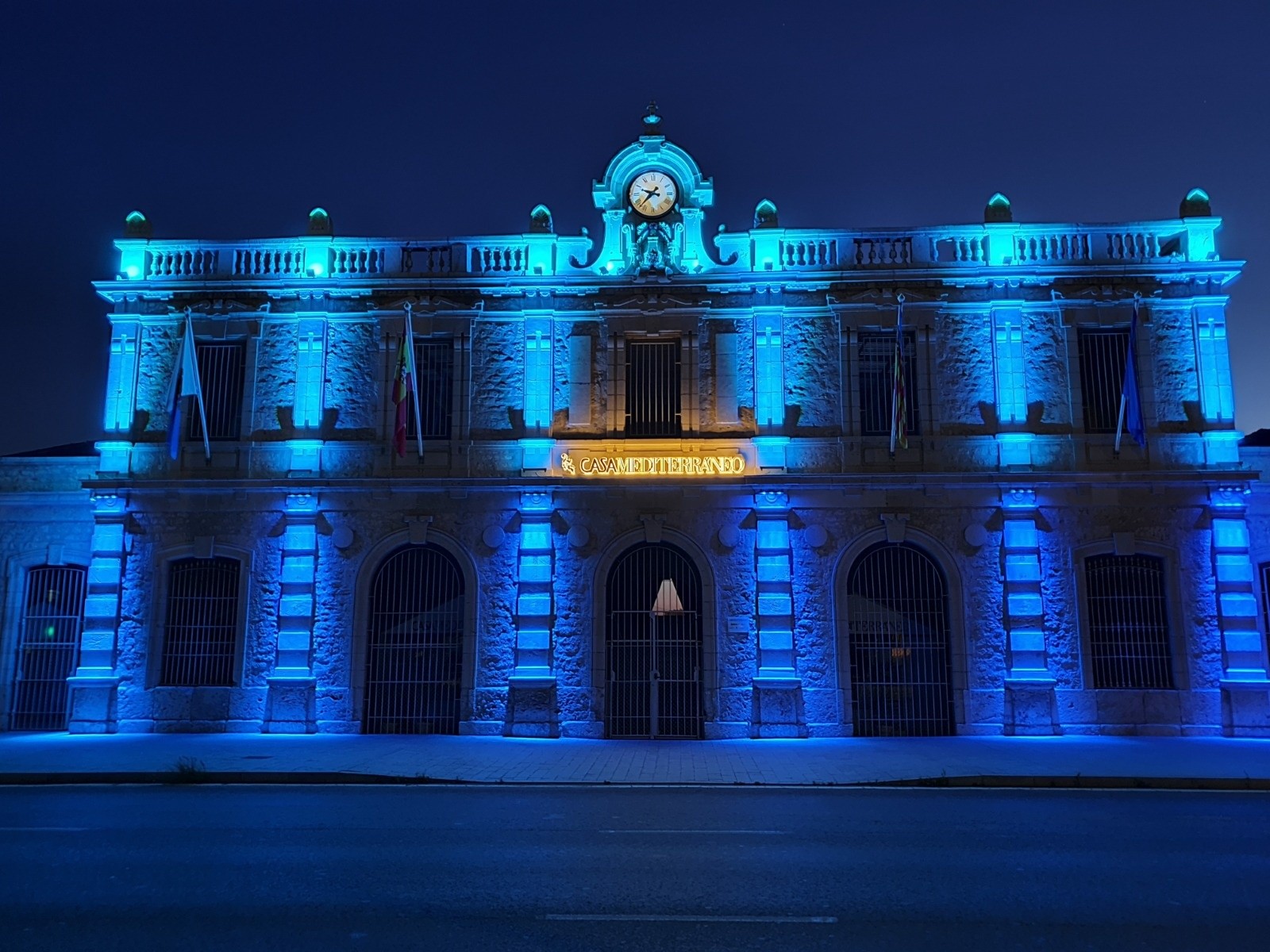 Fachada de Casa Mediterráneo iluminada en azul durante la noche