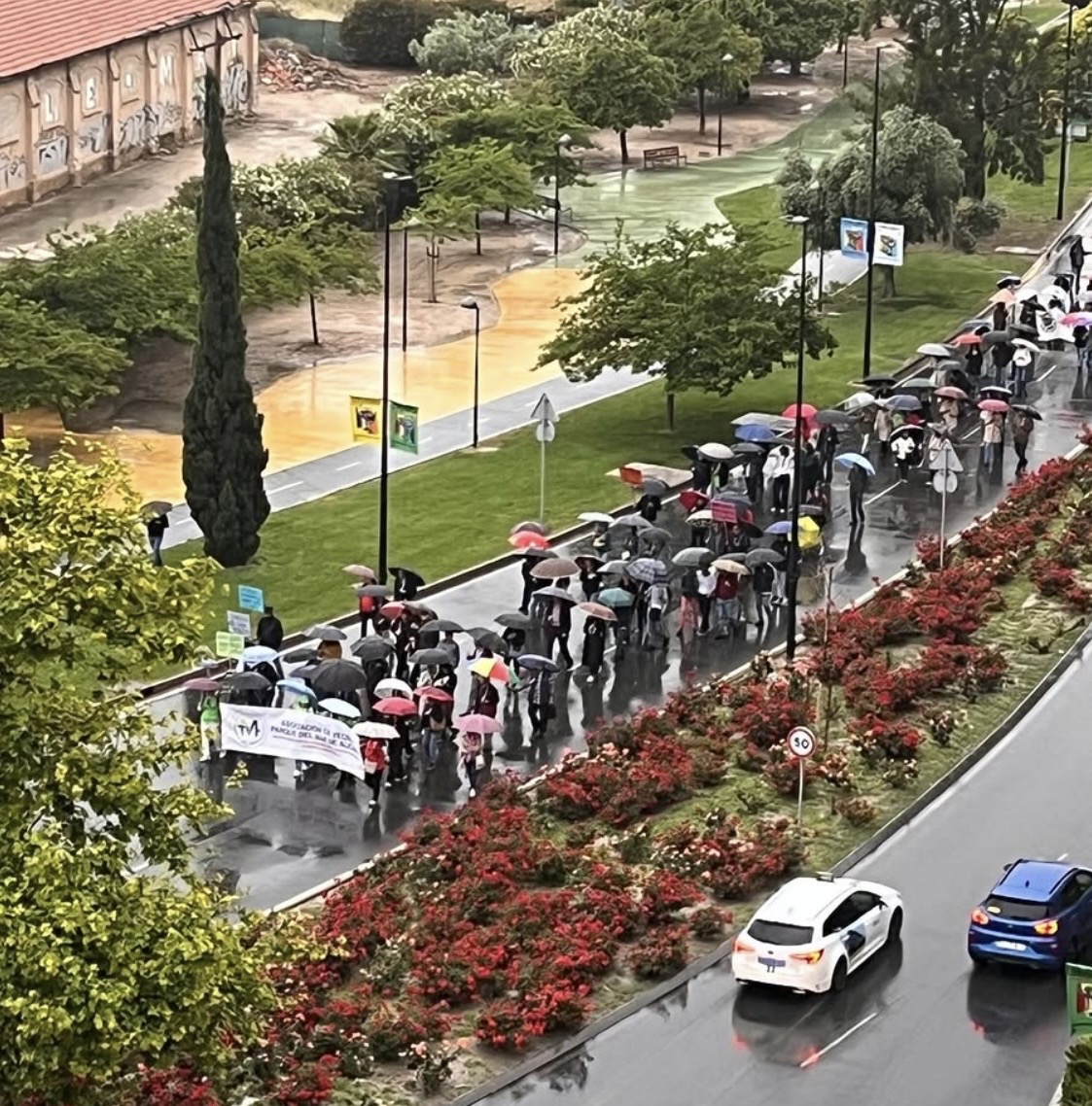 Vecinos manifestándose bajo la lluvia junto al Parque del Mar