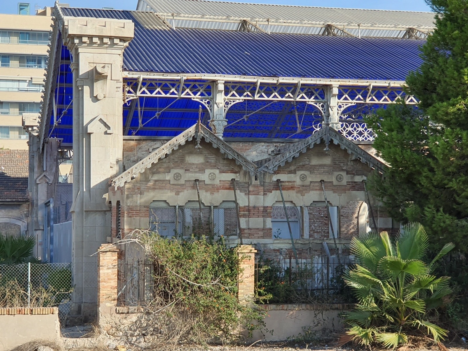 Edificio ferroviario anexo a Casa Mediterráneo con estructura metálica y cubierta azul