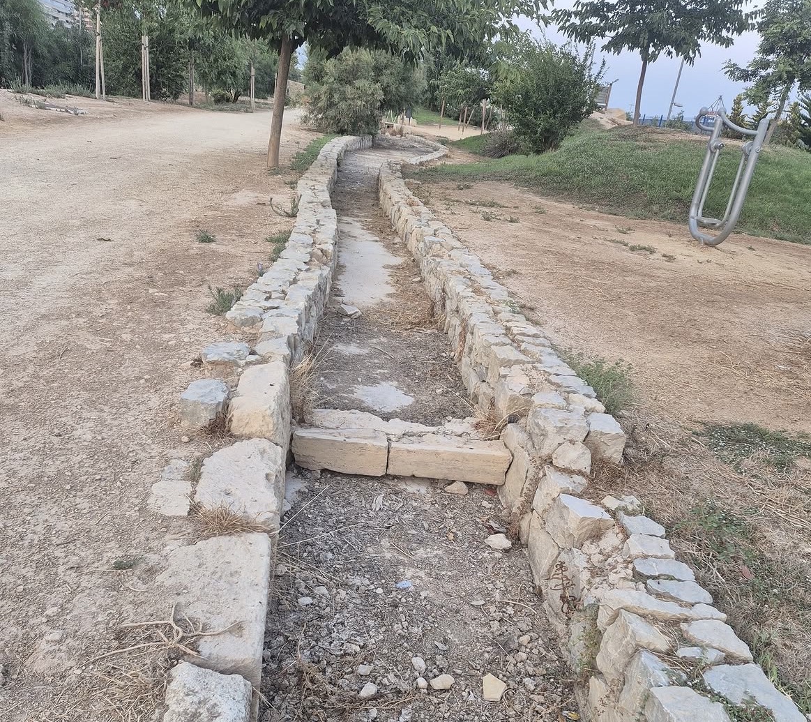 Cauce ornamental seco junto a una zona de ejercicio del Parque del Mar