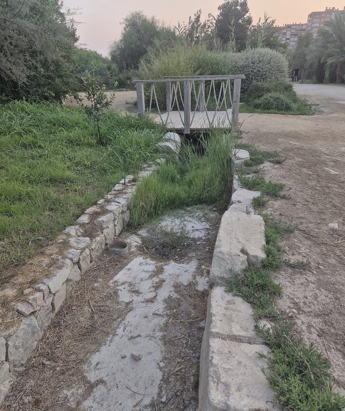 Cauce sin agua bajo un pequeño puente del Parque del Mar